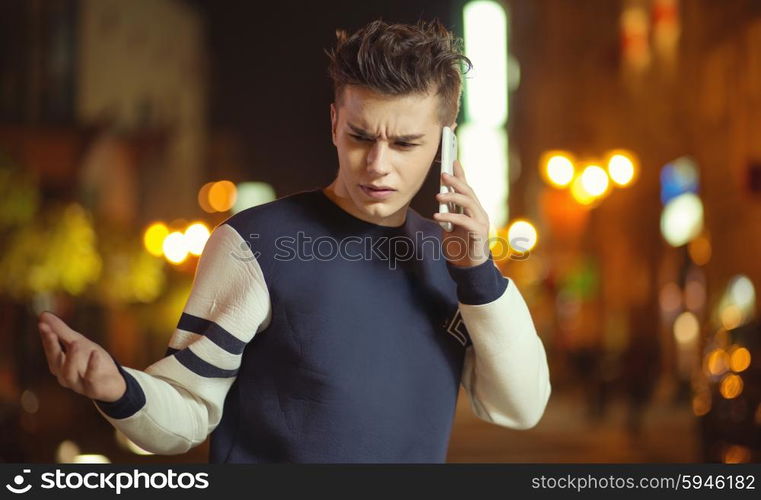 Calm young guy talking on the phone