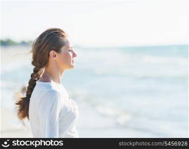 Calm young woman looking into distance at seaside