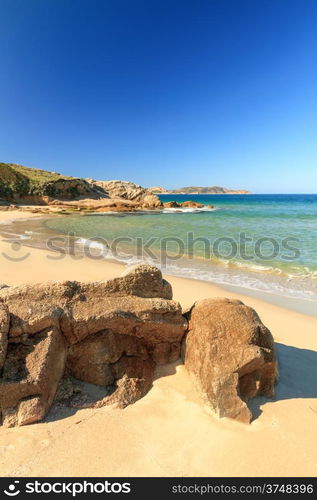 Calvi citadel taken from Plage de Petra Muna near in the Balagne region of Corsica with rocks and sea in foreground