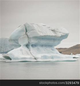 Calving iceberg floating in glacial lake