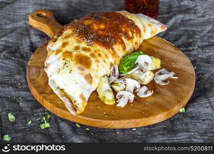 Calzone pizza, filled herbs, cheese and tomatoes