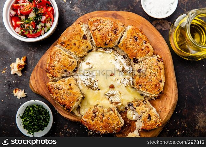 Camembert baked in the oven with herb bread served with tomato salad and olive oil