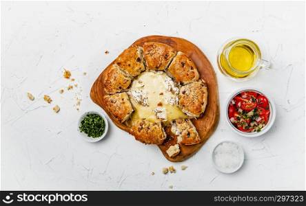 camembert baked in the oven with herb bread served with tomato salad and olive oil