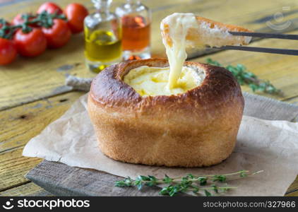 Camembert bread bowl on the wooden background