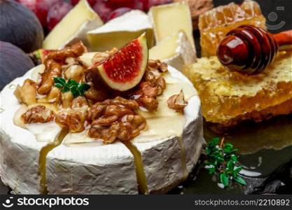 Camembert cheese, cuts and walnuts on stone serving board. Camembert cheese and walnuts on stone serving board