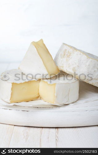 Camembert cheese on cutting board, focus on sliced piece