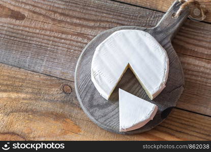 Camembert cheese on the wooden board: top view