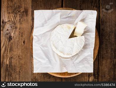 camembert cheese round and section on the table