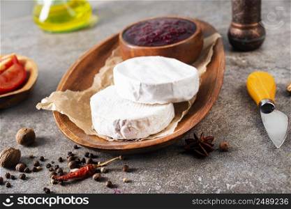Camembert cheese with figs, raspberry jam. Round brie or camambert cheese on cutting board