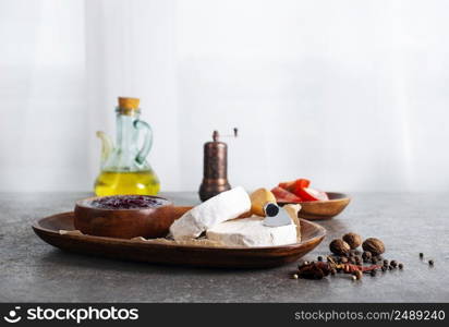 Camembert cheese with figs, raspberry jam. Round brie or camambert cheese on cutting board