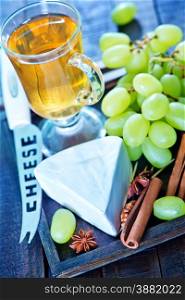 camembert cheese with green grape on the wooden board