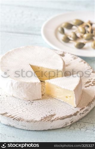 Camembert with capers on the wooden board