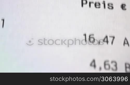 Camera flies along a paper receipt by a dolly. Kamera fahrt eine Einkaufsrechnung von oben entlang.