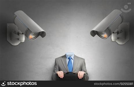 Camera keep an eye on man. Headless businessman in room under CCTV camera control