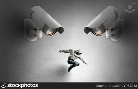 Camera keep an eye on man. Young guy dancer in room jumping under CCTV camera control