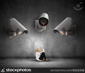 Camera keep an eye on woman. Young scared woman in room under CCTV camera control