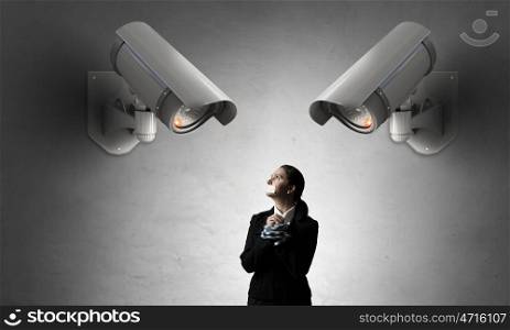 Camera keep an eye on woman. Young tied businesswoman under CCTV camera control
