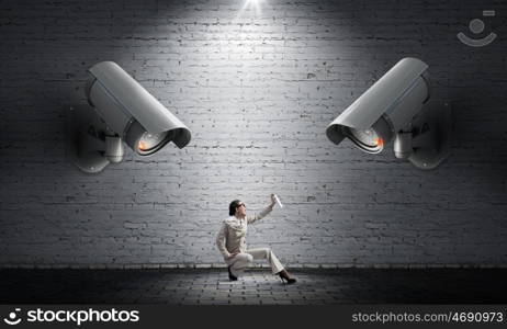 Camera keep an eye on woman. Young woman spraying aerosol on CCTV camera control