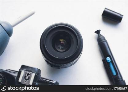 Camera lens with cleaning kit on white background