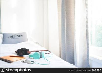Camera, mobile phone and headphone on bed, Clean and cozy bedroom