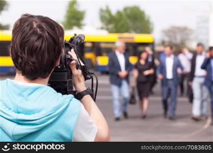 Camera operator filming unrecognizable group of people