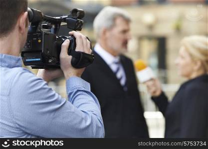 Cameraman Recording Female Journalist Interviewing Businessman