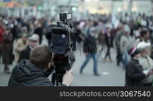 Cameraman shoots people at a crowded place.