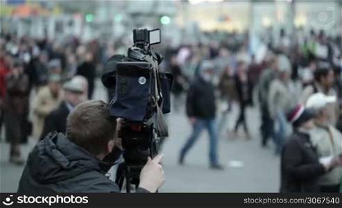 Cameraman shoots people at a crowded place.