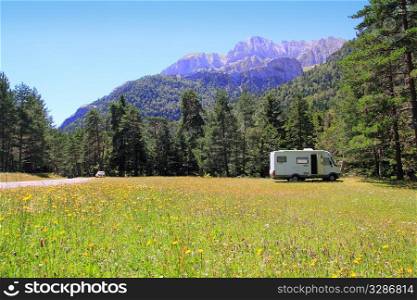 Camper autocaravan meadow in Pyrenees mountain sunny day pine trees forest