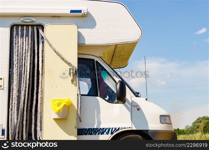 Camper equipment. Trash can with plastic bag inside and caravan door curtain as insect screen. Camping on nature. Holidays and travel in motor home.. Caravan with trash can and door curtain