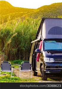 Camper van with roof top tent camping on mediterranean coast. Holidays and travel in mobile home.. Camper van with roof top tent camp on nature