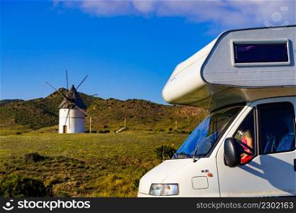 Camper vehicle and wind mill in Cabo de Gata Nijar National Park, Almeria, Spain. Traveling with caravan, motorhome holidays.. Caravan and wind mill in Spain
