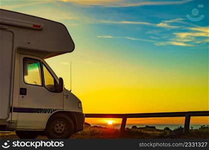 Camper vehicle camping on beach sea shore at sunrise. Adventure, travel with motor home.. Caravan on beach at sunrise