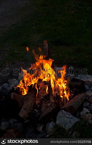 campfire at night in used fireplace with large stones