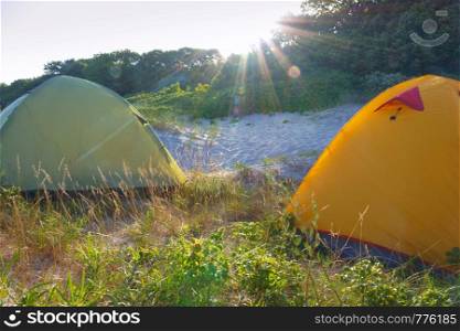 campground at dawn, tourist tents in the morning sun. tourist tents in the morning sun, campground at dawn