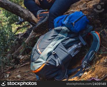 Camping adventure concept from Close up hiking backpack and trekking equipment in forest background.