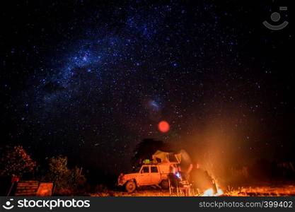 Camping at night with fire and stars in the Hwange National Park, Zimbabwe.