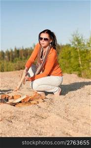Camping happy woman make campfire on beach blue sky