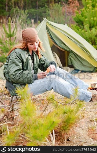 Camping happy woman nature tent cut sausage by fire