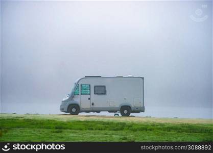 Camping on nature. Camper vehicle at campsite on foggy day. Travel in wintertime.. Camper rv camping on nature. Foggy day