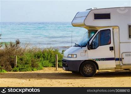 Camping on sea shore. Camper vehicle on beach, mediterranean coast in Spain.. Camper on beach seashore. Holidays trip.