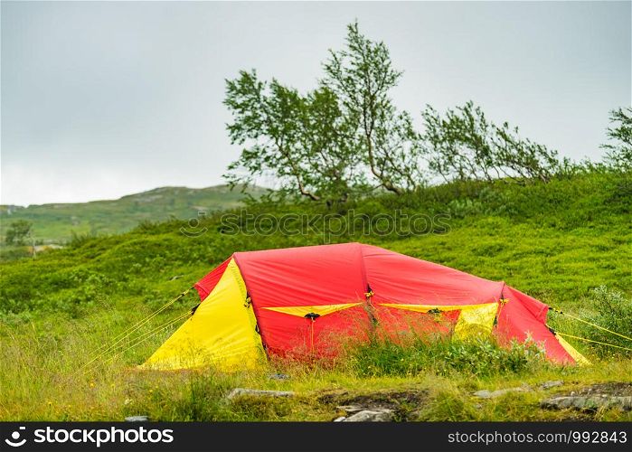 Camping. Red yellow tent on nature in summer. Holidays and travel.. Red tent on nature. Camping