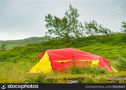Camping. Red yellow tent on nature in summer. Holidays and travel.. Red tent on nature. Camping