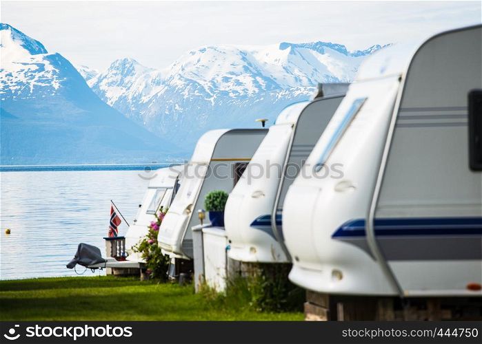 camping site with the blurred camper caravan cars on a fjord shore