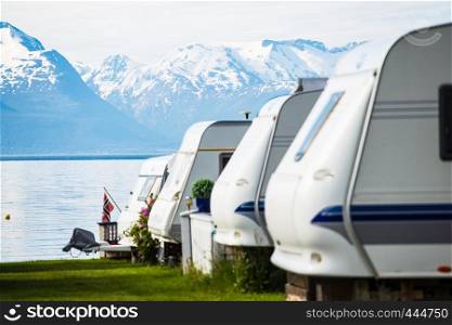 camping site with the blurred camper caravan cars on a fjord shore