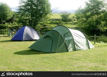 Camping tent field over green grass outdoor field