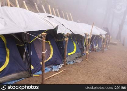 Camping tents in a row in thick cloud and fog near the summit of Acatenango volcano in Guatemala