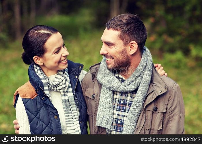 camping, tourism, hike and people concept - happy couple hugging at camp in woods