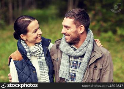 camping, tourism, hike and people concept - happy couple hugging at camp in woods