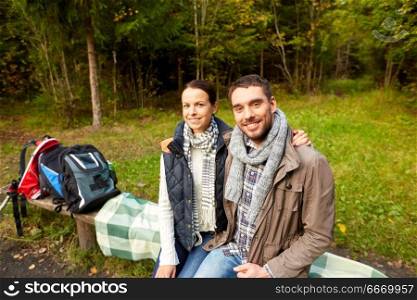 camping, tourism, hike and people concept - happy couple hugging at camp in woods. happy couple hugging at camp in woods. happy couple hugging at camp in woods